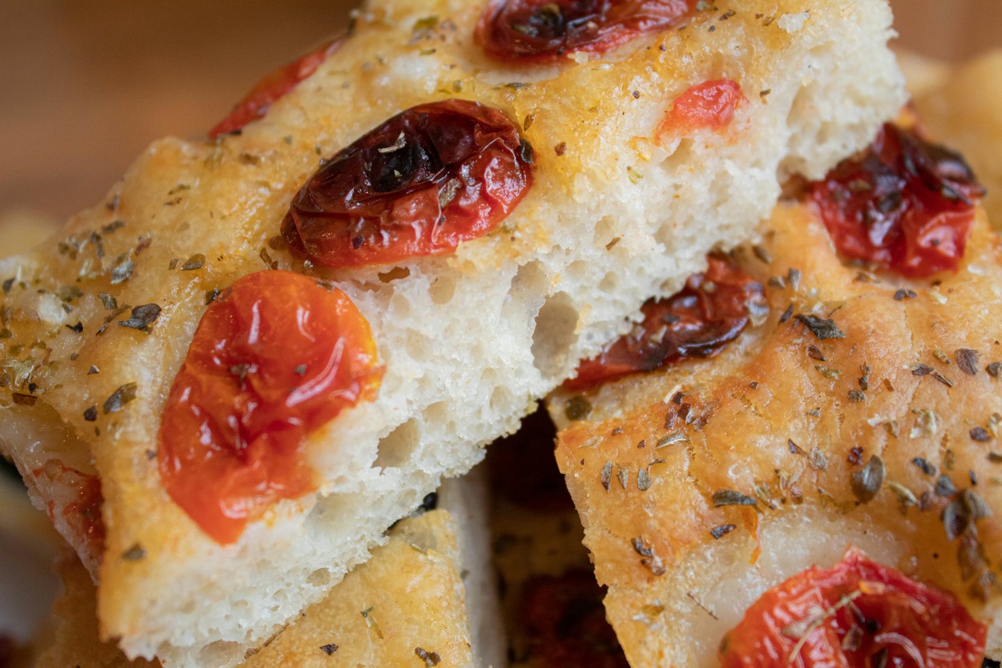 Focaccia appena sfornata con pomodorini arrostiti ed erbe aromatiche.
