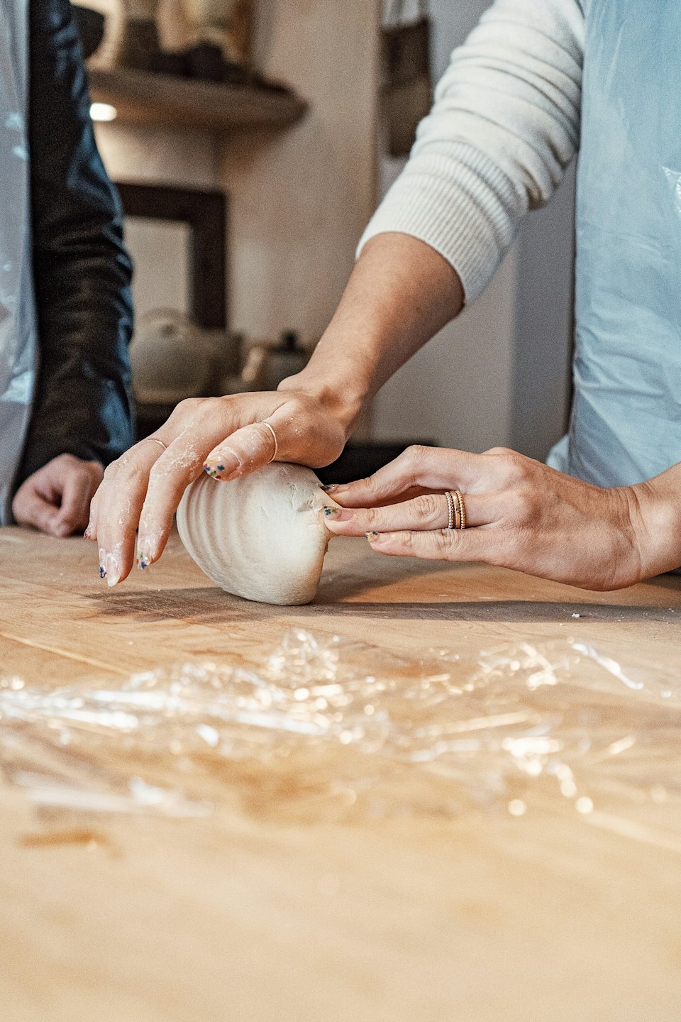 Mani infarinate impastano su un tavolo di legno.