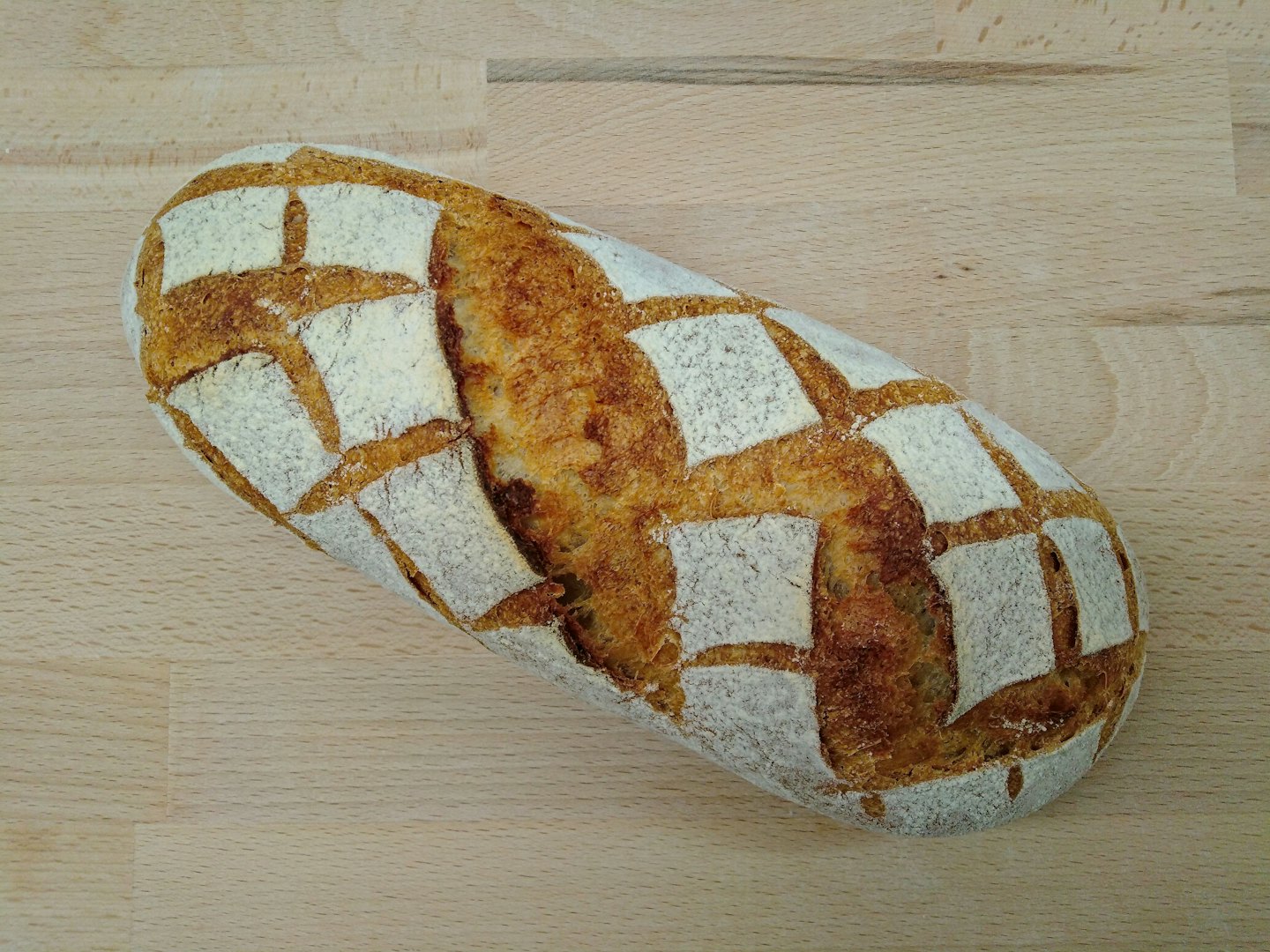 Una pagnotta rustica su un bancone di legno.